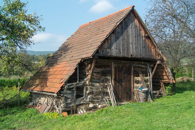 A wooden log barn behind house no. 246 in the Tekov line