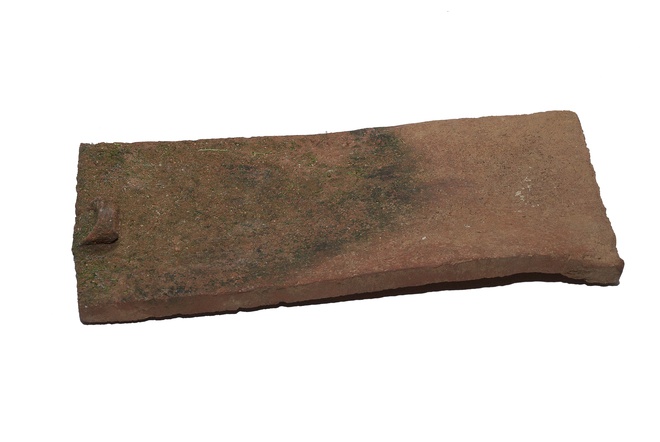 Škridľa bobrovka rozm. 34x15,5x1,5 cm s rovným ukončením a nosom. Nepodarok z areálu bývalej gýmešskej tehelne pravdepodobne patriacej Karolovi III. Forgáčovi (1825–1911).