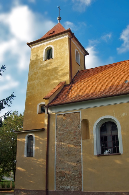 Južná fasáda Kostola Najsvätejšej Trojice s neskororománskym oknom, stredovekými omietkami a maľbami v analytickej sonde